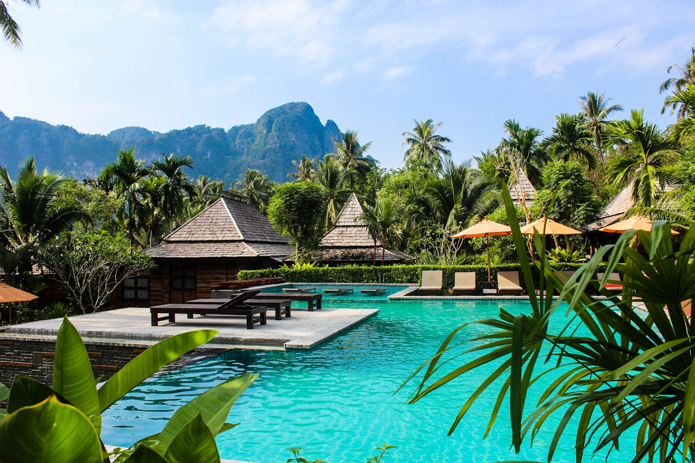 Tropical resort pool with thatched villas